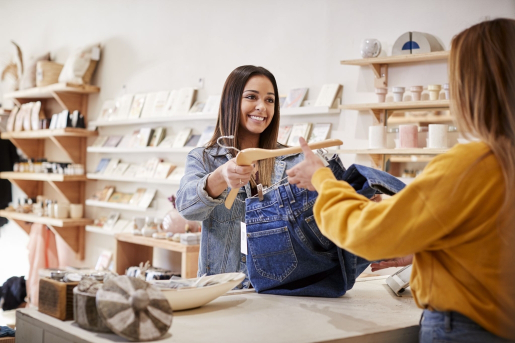 Female sales assistant in gift store serving female customer