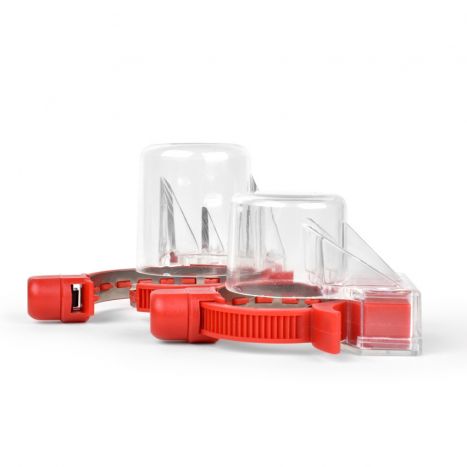 Pair of red circular security tool with cap to prevent in-store consumption of beverages.
